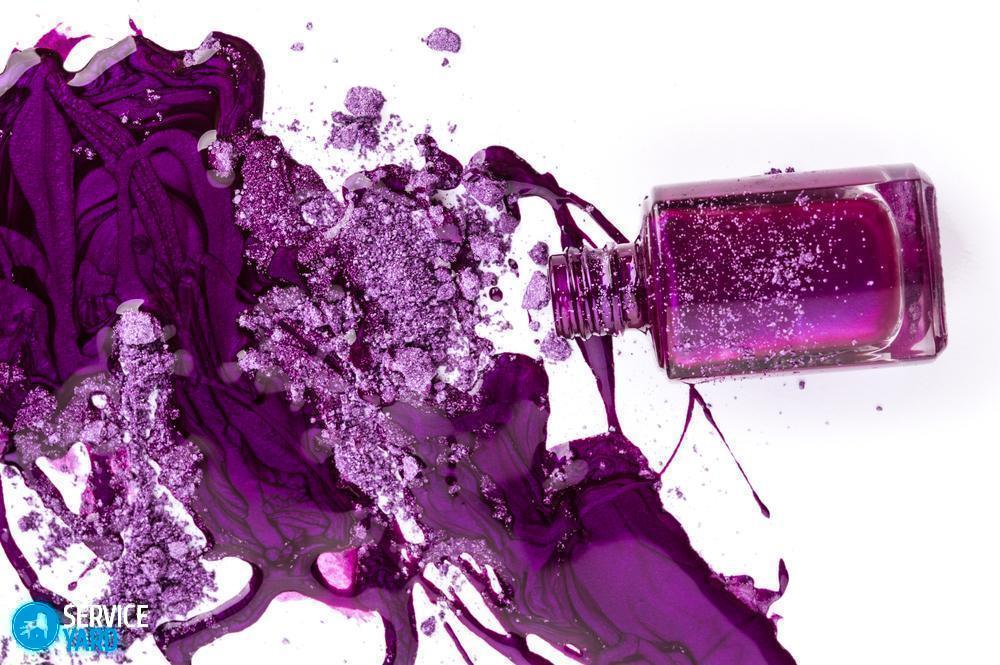 Purple nail polish and crushed eye shadow on white background